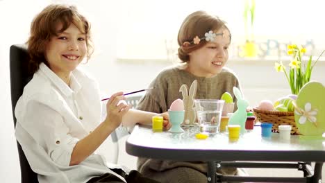 Vorbereitung-auf-Ostern.-Bruder-und-Schwester-Dekorieren-Ostereier.-Kinder-lachen-fröhlich.-Slow-Motion