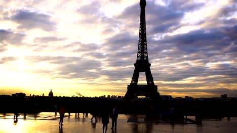 Passagiere,-die-zu-Fuß-in-der-Nähe-von-Eiffelturm-mit-Sonnenuntergang-Hintergrund