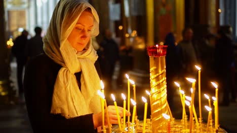 Woman-lights-the-candle-in-russian-orthodox-church.