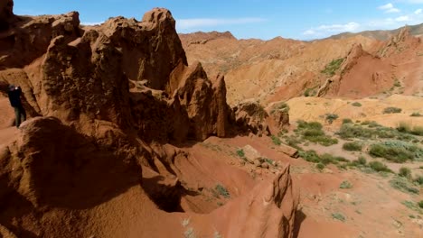 Tourist-Man-Takes-Picture-of-Red-Canyon-and-Blue-Sky-at-Sunny-Day.-Aerial-View