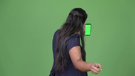 Young-overweight-beautiful-Indian-businesswoman-against-green-background