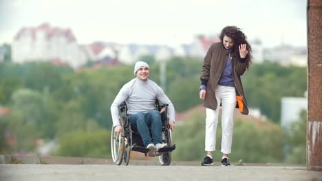 Happy-behinderte-Menschen-im-Rollstuhl-mit-glückliche-junge-Frau-läuft-auf-der-Stadtstraße