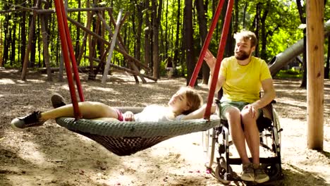 Woman-is-lying-on-a-swing-and-a-man-is-pushing-a-swing