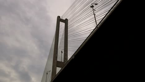 Gran-puente-sobre-el-río.-Arquitectónica-del-edificio-conectando-las-dos-orillas-de-la-ciudad.-Estructura-masiva.-Un-camión-lleva-carga-a-través-del-puente.