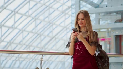 Smiling-female-blogger-listening-favorite-songs-in-headphones-while-posing-for-selfie-on-smartphone-camera,-hipster-girl-enjoying-radio-broadcast-making-photo-for-picture-in-social-networks-on-mobile