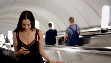 Schönheitsfrau-auf-Rolltreppe-in-U-Bahn-oder-U-Bahn-lesen-Nachricht-in-Telefon-Lächeln