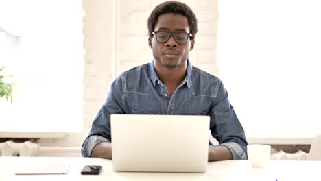 African-Man-Using-Phone-and-Laptop-for-information