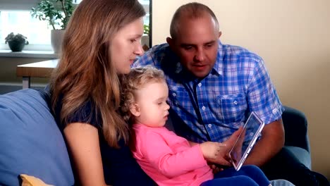 Family-members-have-fun-with-tablet-on-sofa.