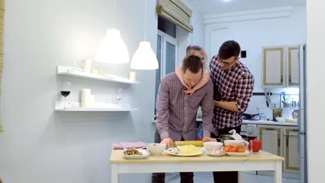 Familia-gay-con-hija-niño-cocinar-pizza-juntos-en-la-cocina-y-abrazando.