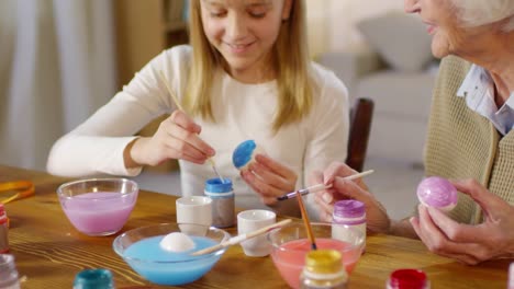 Grandmother-and-Granddaughter-Painting-Eggs-with-Gouache