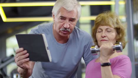 Two-Pensioners-with-Tablet-in-Gym