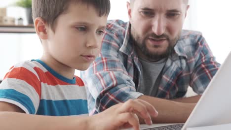 Boy-lernen,-Laptop-mit-Vater-zu-Hause-zu-benutzen