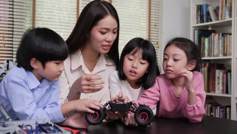 Teacher-and-student-work-on-a-programable-robot-at-school-science-class-project.-Technology-and-Education-concept.