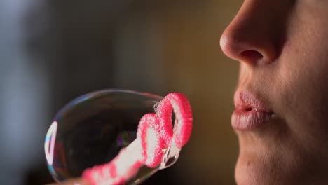 closeup-macro-slow-motion-lips-blowing-bubbles-from-pink-bubble-wand