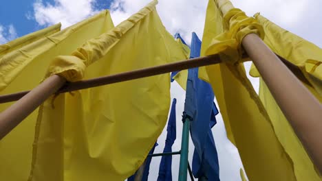 Ukrainische-Flaggen-flattern-im-Wind-gegen-einen-blauen-Himmel.-Helle-gesättigte-gelb-blaue-Farben.