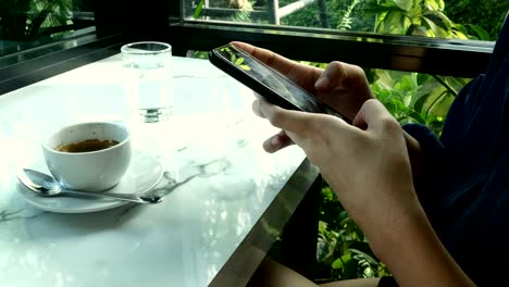 Junge-Frau-plaudert-und-textet-im-Smartphone-Café.