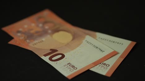 Banknotes-10-euro-slowly-falling-on-the-black-table.-Closeup.-Slow-motion