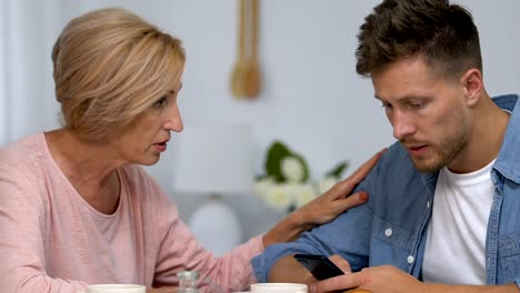 Son-ignoring-live-communication-with-mother,-chatting-on-smartphone,-conflict