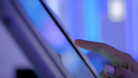 Woman-hand-using-touchscreen-display-of-floor-standing-tablet-kiosk