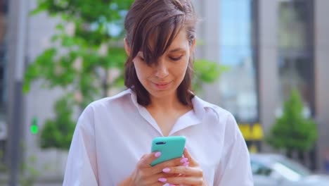 retrato-feliz-mujer-sonriente-sosteniendo-smartphone-urban-city-fondo