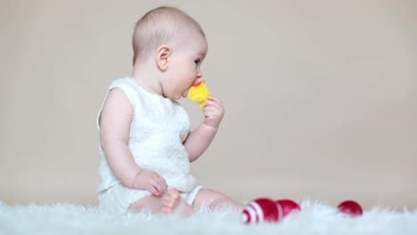 Lindo-niño-pequeño-niño,-jugando-con-huevos-de-pascua-de-colores-y-patos-decorativos-pequeños,-tiro-aislado,-fondo-beige