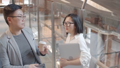 Two-Yong-Asian-Colleagues-Having-Talk