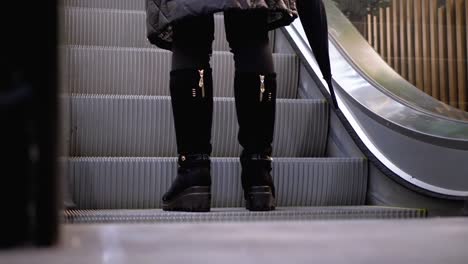 Legs-of-People-Moving-on-an-Escalator-Lift-in-the-Mall.-Shopper's-Feet-on-Escalator-in-Shopping-Center