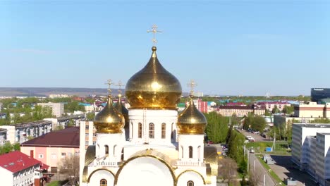 Shining-Gold-Domes-on-Church-among-Modern-City-Aerial-View