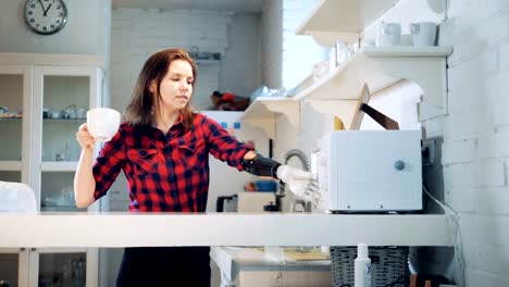 Una-chica-usando-prótesis-de-mano-para-sostener-una-taza,-de-cerca.