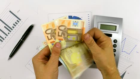 Counting-euros-on-a-background-of-a-calculator-and-a-pen