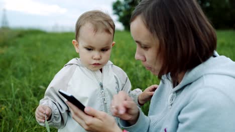 Woman-showing-something-to-her-child-on-the-smartphone.