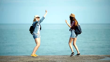 Young-women-enjoying-and-dancing-on-a-sea-shore.