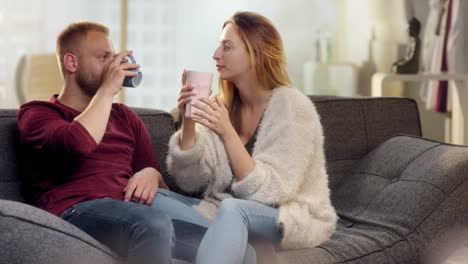 Sweet-young-couple-drinking-tea-on-couch