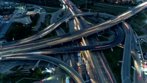 Vertical-descendente-vista-aérea-de-tráfico-en-el-intercambio-de-la-autopista-por-la-noche.