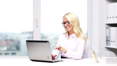 woman-secretary-or-student-in-eyeglasses-with-laptop-typing-in-office