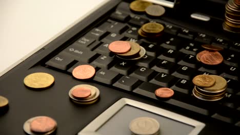 Coins-on-a-laptop-isolated-on-white-background