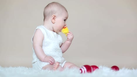 Niedlichen-kleinen-Kleinkind-Baby-jungen-spielen-mit-bunten-Ostereiern-und-kleinen-Zierenten,-isoliert-erschossen,-Beige-Hintergrund