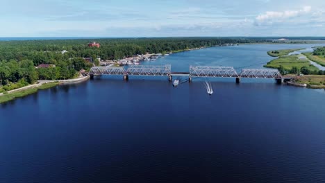 Bahnbrücke-Drohne-Flightabove-Lielupe-Flusses-Jurmala-Stadt,-grüne-Natur,-Schiff-Boot