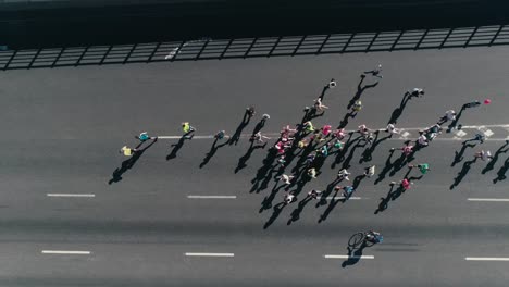 Marathon-laufen-auf-der-Straße.-Folgende-Gruppe-von-Athleten-Slow-Motion.-Ansicht-von-oben