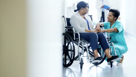 African-American-mujer-enfermera-y-paciente-en-silla-de-ruedas