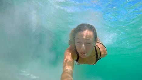 Selfie-portrait-of-young-woman-underwater-swimming-in-clear-blue-water-enjoying-vacations-in-Italy-Sardinia