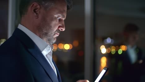 Man-Typing-on-Smartphone-in-Dark-Office-in-the-Night