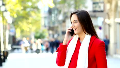 Woman-talking-on-phone-in-the-street-in-winter