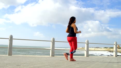 Vista-lateral-de-movilidad-mujer-caminando-en-el-paseo-marítimo-4k