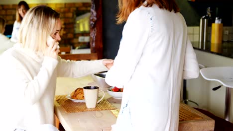 Lesbian-couple-having-breakfast-in-kitchen-4k