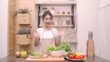 Mujer-asiática-blogger-usando-cámara-de-grabación-cómo-hacer-comida-sana-ensalada-video-para-su-abonado,-verduras-orgánicas-de-uso-femenino-preparar-ensalada-para-cuerpo-en-forma-en-casa.-Concepto-de-comida-sana.