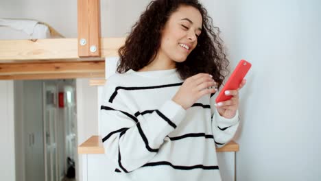 Encantadora-mujer-joven-usando-el-teléfono-en-moderno-apartamento-elegante.