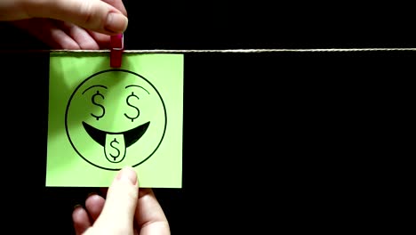 Two-stickers.-Emotions.-On-the-green-sheet-on-the-face-expression-love-of-money.-On-the-right-yellow-page-is-the-percent-symbol.-Black-background.