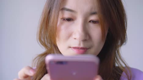 Asian-woman-using-cellphone-in-living-room