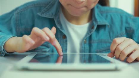 closeup-of-little-girl-hands-in-jeans-wear-playing-games-on-tablet